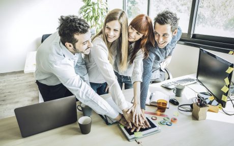 Group of young people employee coworkers stacking hands in urban coworking place